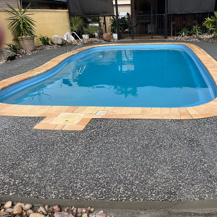 After: exposed aggregate surround and orange coping around the pool