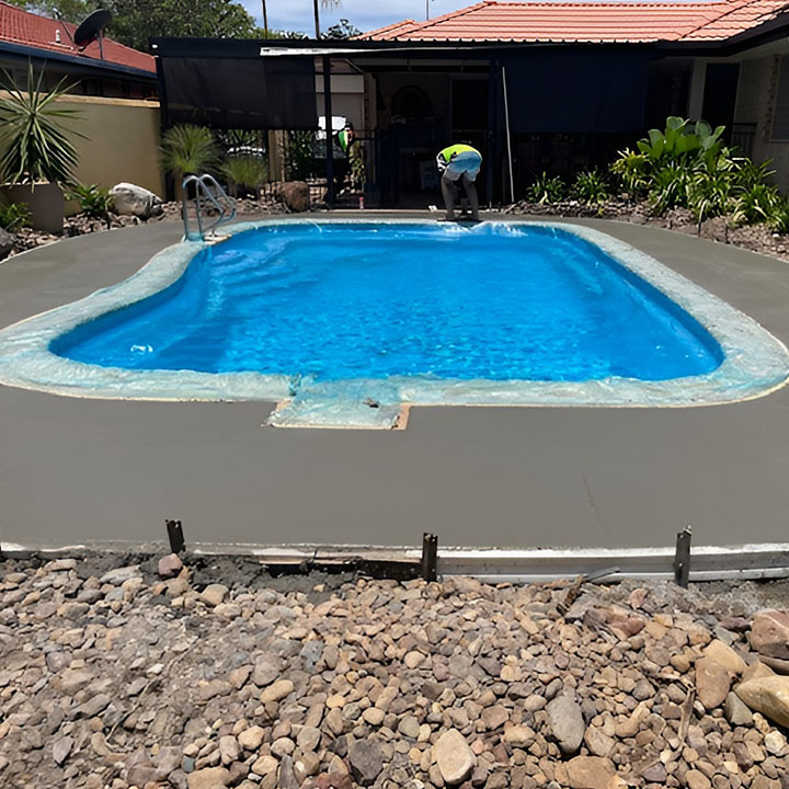 Before: fresh concrete laid around a pool inside timber formwork