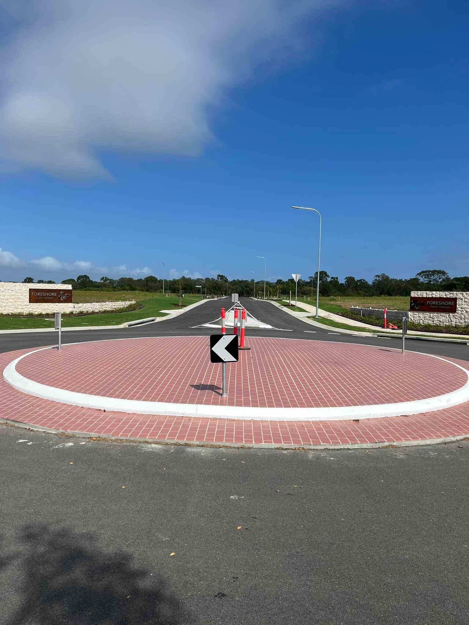 Red-paved roundabout with a white concrete kerb, tall view